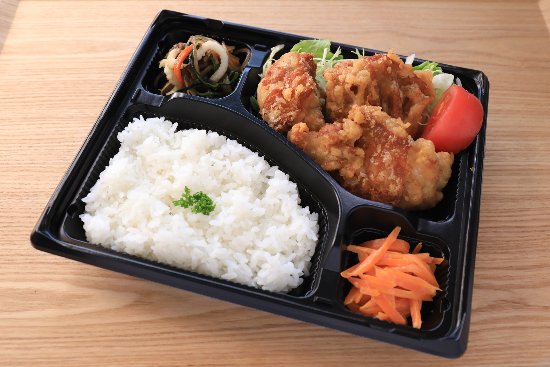 白米・唐揚げ・野菜のきんぴら・にんじんなどが入った宅配弁当